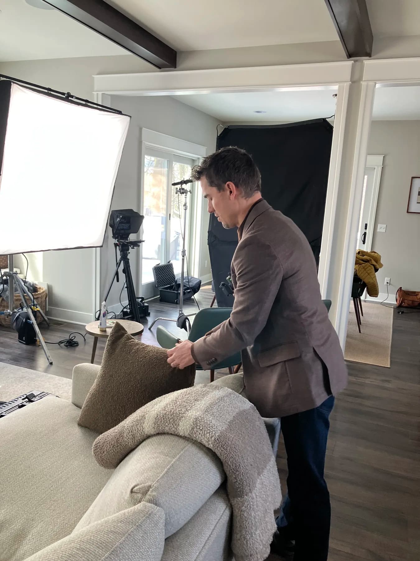 Brian Boer seated in the living room interview setup while SALT lights the Boer Insurance brand story shoot.