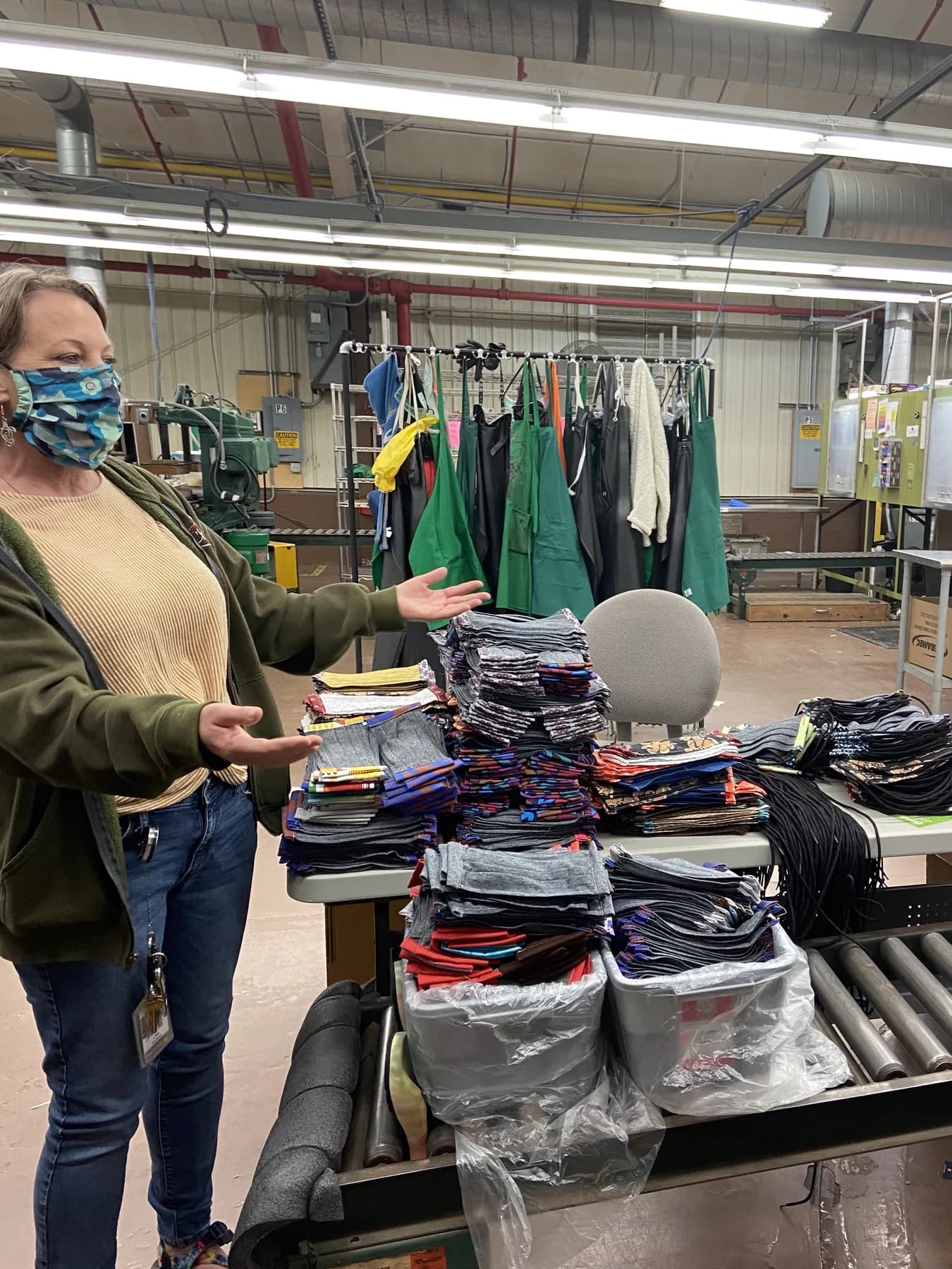 Lisa Kondrat stands beside stacks of masks sewn by Wolverine Worldwide employees inside the ReChaco factory.