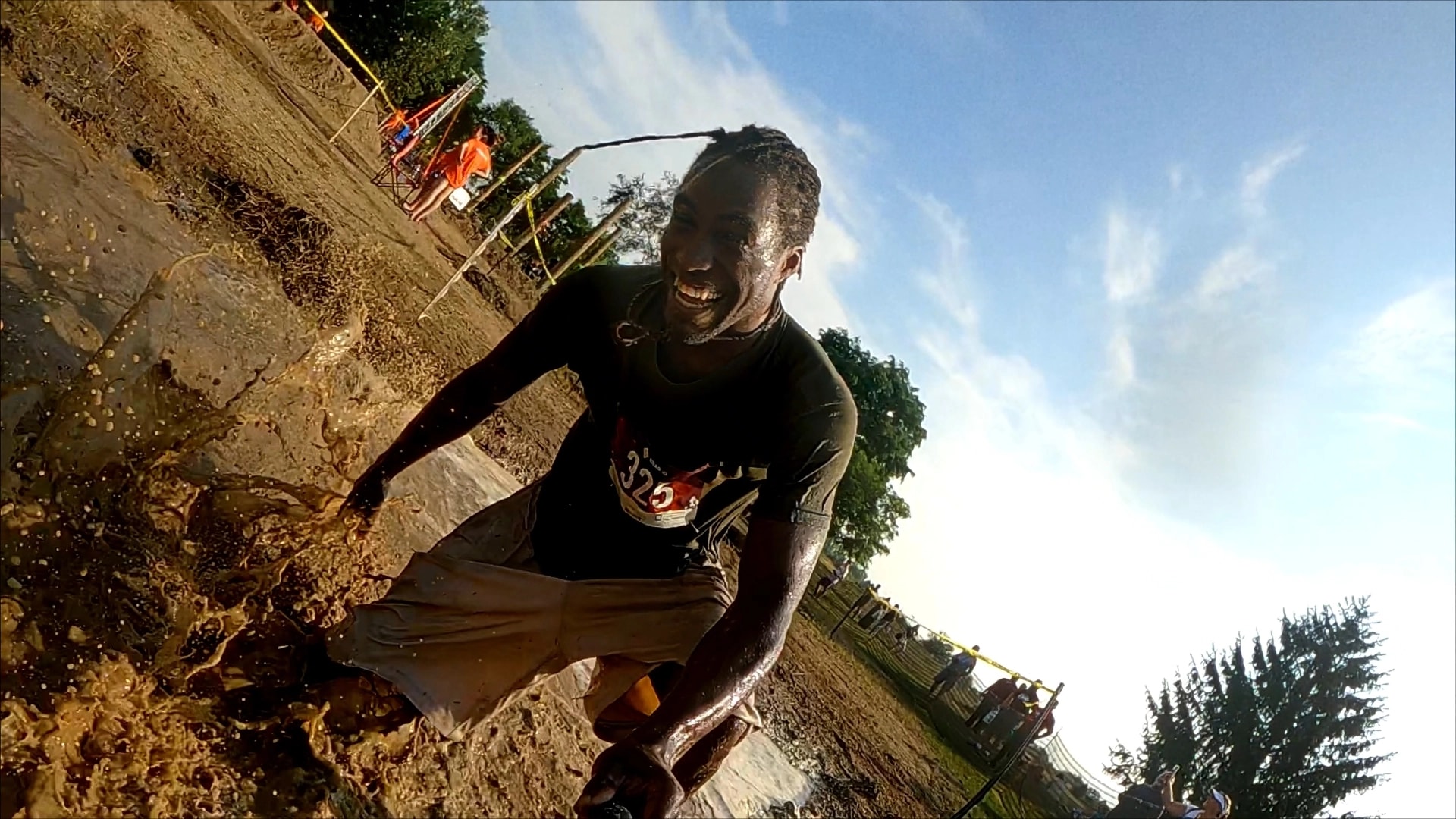 Mud-covered runners take on obstacles at the Grand Rapids Mud Run in Kentwood, Michigan