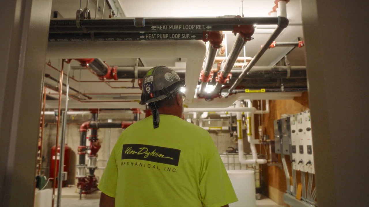 Van Dyken Mechanical crew member walks through a live mechanical room during the VDM and GVA recruitment campaign.