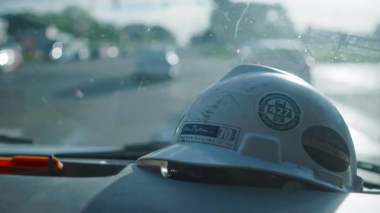 A Van Dyken Mechanical hard hat rests on a dashboard before a service call during the recruitment campaign shoot.