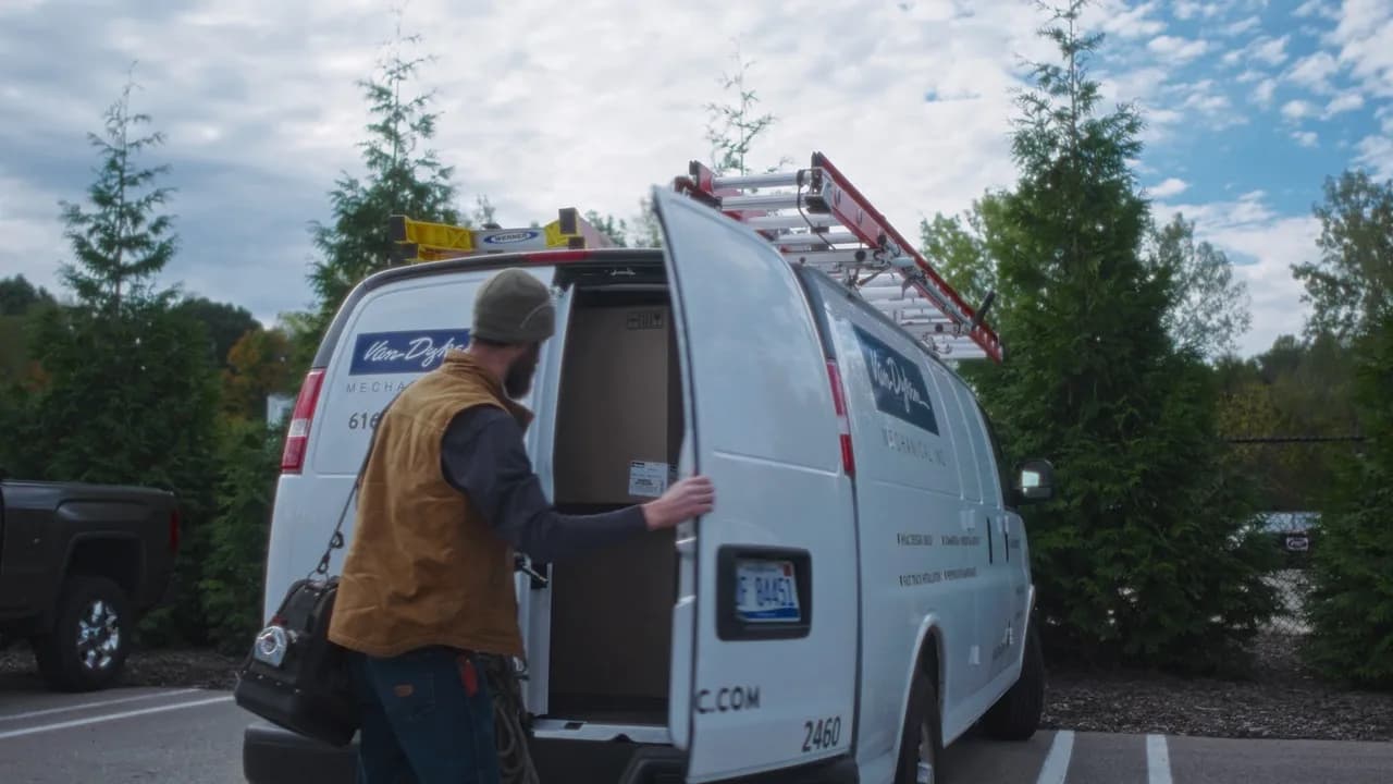 A Van Dyken Mechanical technician opens the back of a service van before starting work on site.